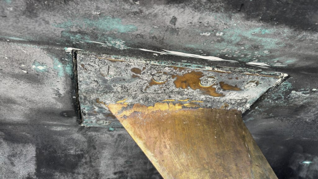visible oxidation around a yacht rudder mounting plate during inspection
